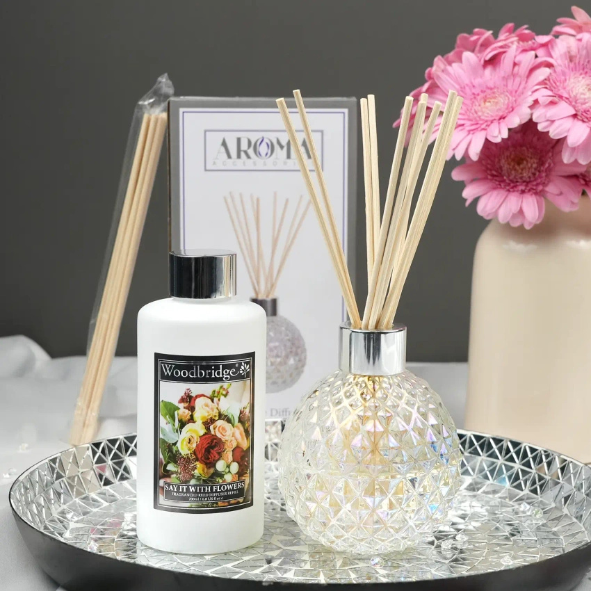 Bouteille vide transparente avec bâtons diffuseurs dans une boîte à Woodbridge Candle
